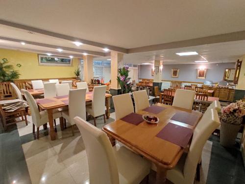 a dining room with wooden tables and white chairs at Villa Aleksandra - T in Rafailovici