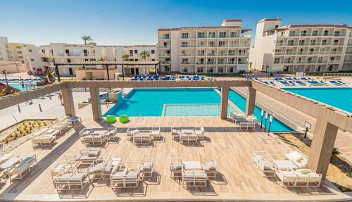 een uitzicht over een zwembad met stoelen en tafels bij Amarina Abu Soma Resort & Aquapark in Hurghada