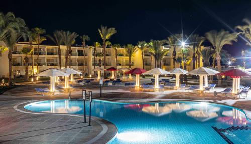 a resort pool with umbrellas and chairs and a hotel at Amarina Abu Soma Resort & Aquapark in Hurghada