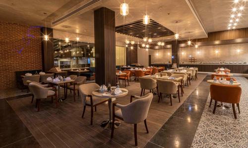 a restaurant with tables and chairs in a room at Amarina Abu Soma Resort & Aquapark in Hurghada