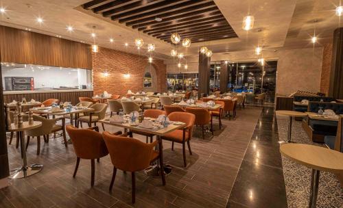 a restaurant with tables and chairs and a bar at Amarina Abu Soma Resort & Aquapark in Hurghada