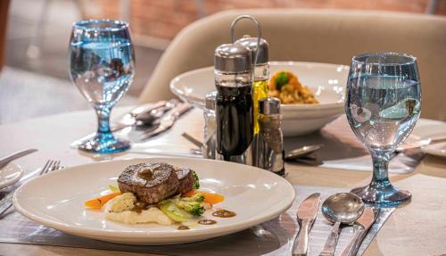a table with a plate of food and wine glasses at Amarina Abu Soma Resort & Aquapark in Hurghada