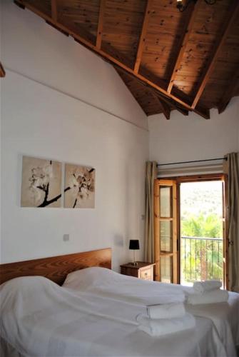 a bedroom with a white bed and a window at Unique Stonehouse Traditional Villa in Ayia Anna in Ayia Anna