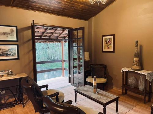 a living room with a table and chairs and a window at Refúgio das Araucárias in Ibiúna