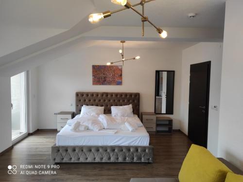 a bedroom with a large bed and a yellow chair at Villa TEMA in Ohrid