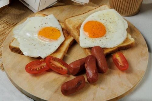 a plate of breakfast foods with eggs sausage and toast at Athens Panorama Project in Athens