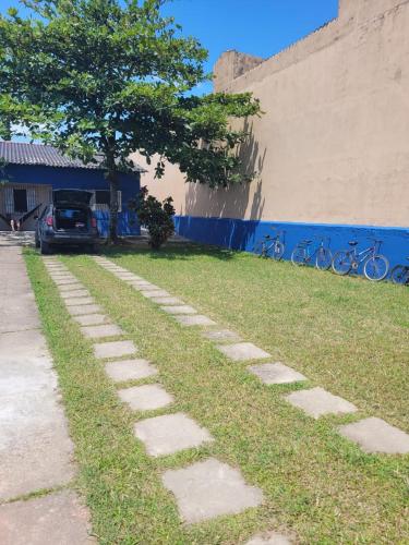 a cobblestone path in the grass next to a building at Temporada no Paraíso in Ilha Comprida
