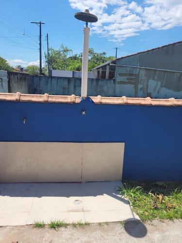 a blue wall with a pole on top of it at Temporada no Paraíso in Ilha Comprida