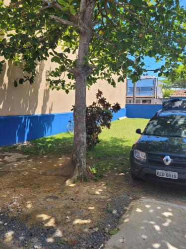 a car parked next to a tree next to a building at Temporada no Paraíso in Ilha Comprida