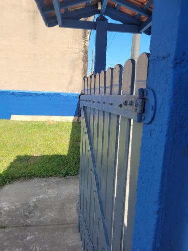 a blue gate in front of a blue wall at Temporada no Paraíso in Ilha Comprida
