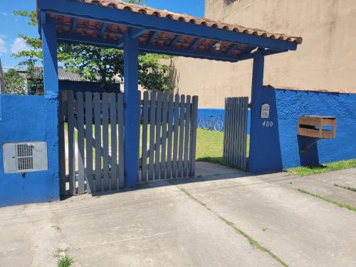 a blue gate with a bench in front of a building at Temporada no Paraíso in Ilha Comprida