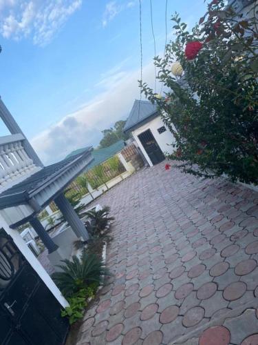a brick walkway with a bench in front of a house at Apex guest facility in Buea