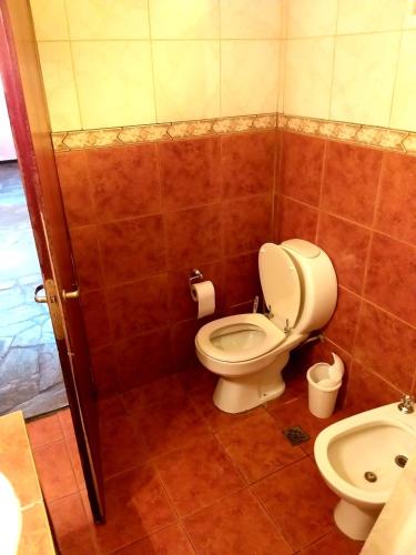 a bathroom with a toilet and a sink at Alojamiento cerca de Ezeiza in Canning