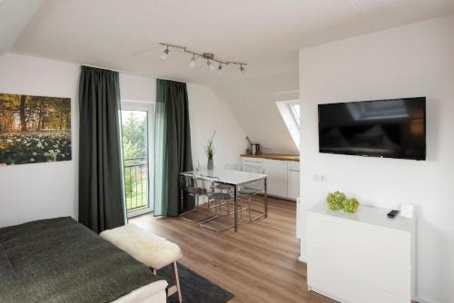 ディリンゲン・アン・デア・ドナウにあるLandgasthof zur Sonneのベッド、テーブル、テレビが備わる客室です。