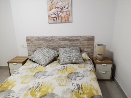 a bedroom with a bed with two night stands and a painting at Casa Carmen 2 in Cudillero