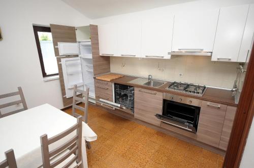 a kitchen with a stove and a sink and a table at Apartament VV in Pula