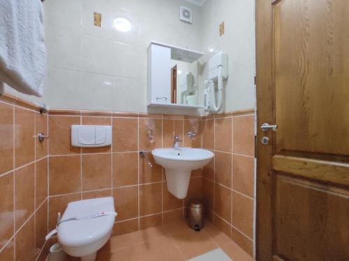 a bathroom with a toilet and a sink and a mirror at Villa Aleksandra - T in Rafailovici