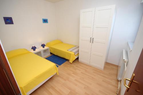 mały pokój z 2 łóżkami i szafą w obiekcie Apartament VV w Puli
