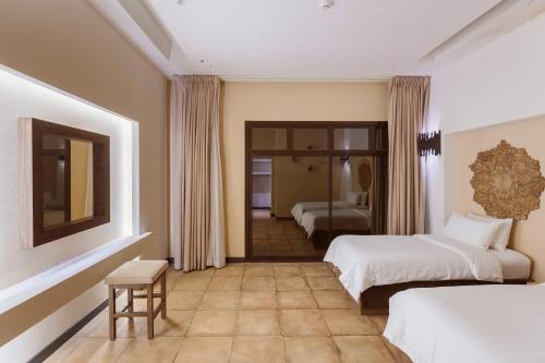 a hotel room with two beds and a table at The Cliff Resort in Riyadh
