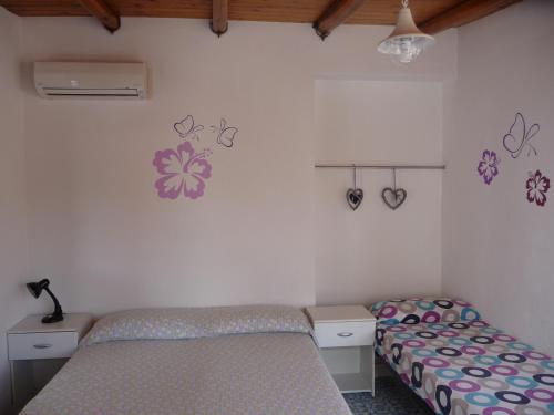 1 dormitorio con 2 camas y corazones en la pared en Le Terrazze en Lipari