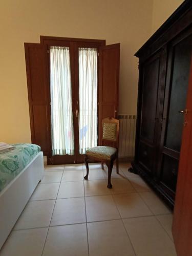 a bedroom with a chair and a bed and a dresser at LE GINESTRE in Sulmona