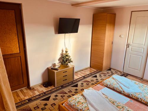 Habitación con 2 camas y un árbol de Navidad en la pared en Casa BOICO en Gura Humorului