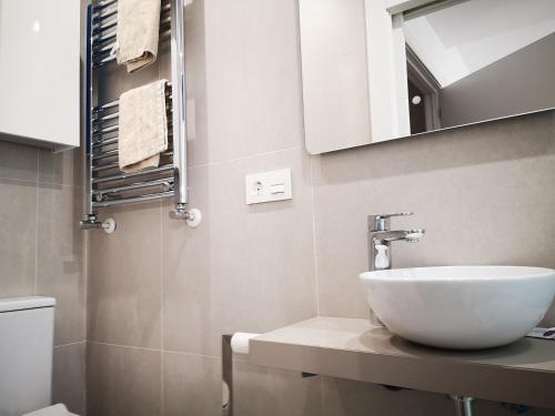 een badkamer met een witte wastafel en een spiegel bij Casa Carmen 1 in Cudillero