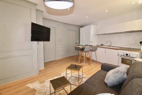 a living room with a couch and a kitchen at Lovely Apartment Heart of Golden Square Fiber Wifi in Nice