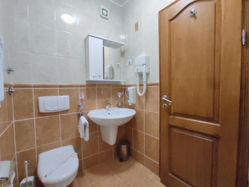 a bathroom with a toilet and a sink and a door at Villa Aleksandra - T in Rafailovici