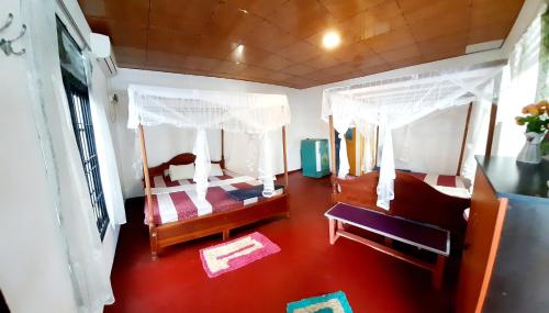 ディックウェラにあるHiriketiya Cinnamon Gardenの赤い床の客室で、ベッド2台が備わります。