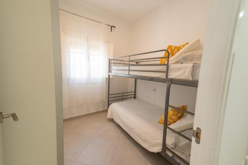 a room with two bunk beds and a window at Apartamento Centro Calle Plata in Sanlúcar de Barrameda