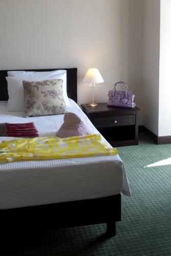 a bedroom with a bed and a table with a lamp at Margarona Royal Hotel in Preveza