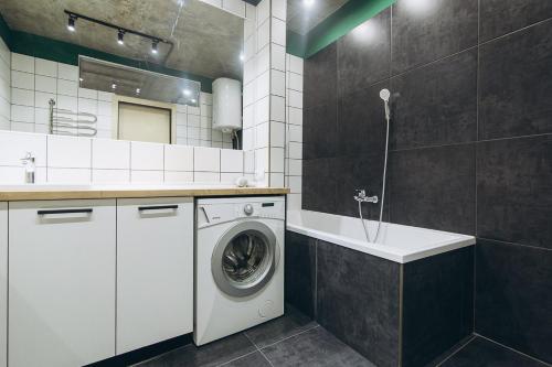 a bathroom with a washing machine and a sink at Lux apart Greatest Luxury Apartment Loft in Sumy