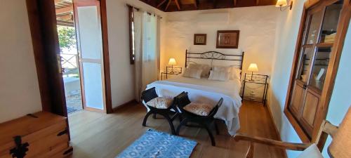 蒂哈拉費的住宿－La Somadita Tinizara，一间卧室配有一张床和两把椅子