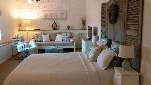 a living room with a large bed and a couch at La Grange de Gournay in  Gournay-Loizé