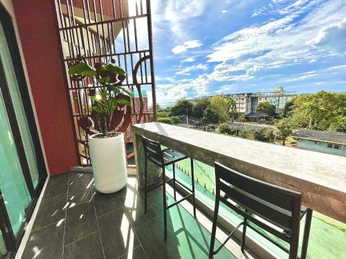 a balcony with two chairs and a potted plant at The Poem Hotel in Mae Pim