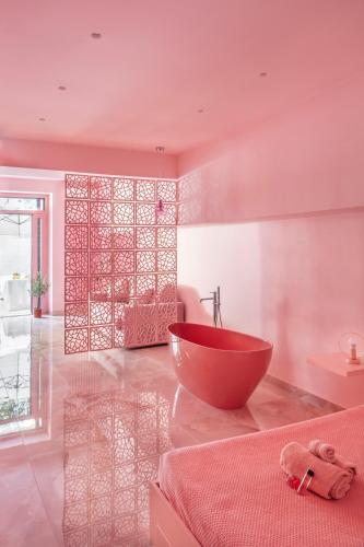 ein Badezimmer mit einer roten Badewanne in einem rosa Zimmer in der Unterkunft THULITE casa vacanze in Gaeta