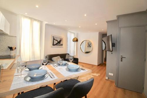 a living room with a dining room table with chairs at Lovely Apartment Heart of Golden Square Fiber Wifi in Nice