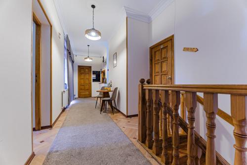 a hallway with a staircase with a table and a door at Jako Hotel Old Tbilisi in Tbilisi City