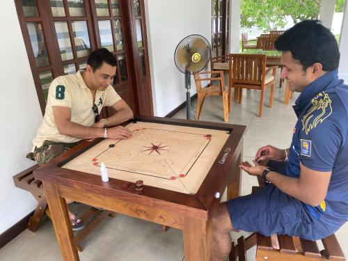 two men are playing a game on a table at Hummingbird Leisure Villa-Anuradhapura in Anuradhapura