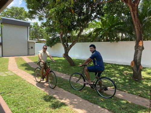 two men riding bikes down a sidewalk at Hummingbird Leisure Villa-Anuradhapura in Anuradhapura