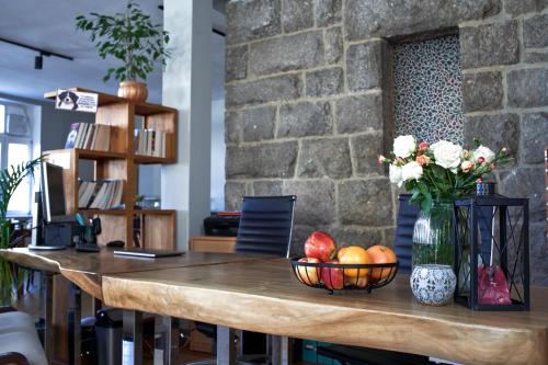 una mesa con un bol de fruta y un jarrón de flores en Perła Sudetów by Stay inn Hotels, en Karpacz