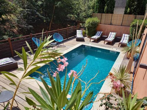 a swimming pool in a backyard with chairs and plants at Hôtel Restaurant Notre Dame in Collobrières