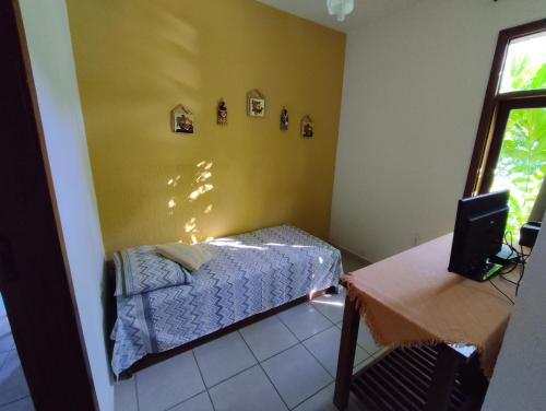a small bedroom with a bed and a table at Flat Barra in Barra Grande