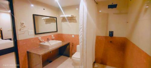 een badkamer met een wastafel, een bad en een toilet bij Zenith Hotel - Delhi Airport in New Delhi