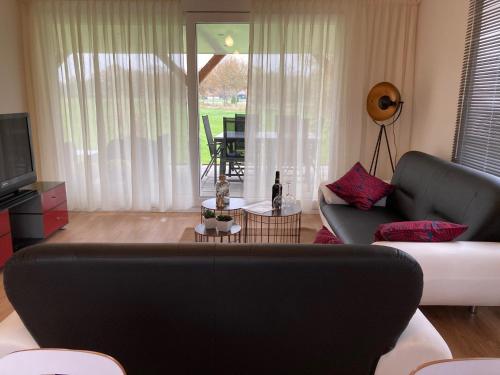 a living room with a couch and a television at Vakantiehuis Ervedriestreek in Den Ham