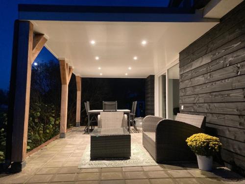 a patio with a table and chairs and a laptop on it at Vakantiehuis Ervedriestreek in Den Ham
