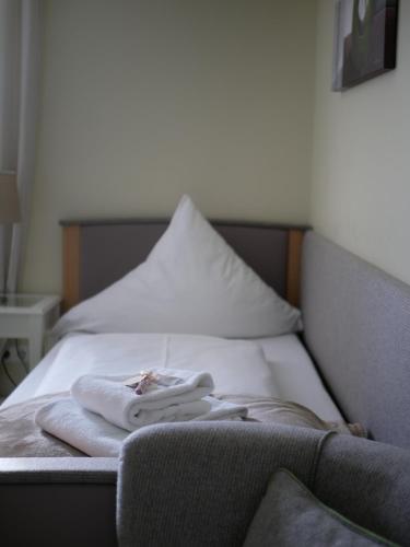 a bed with two towels sitting on top of it at Gasthof Ginzinger in Mauerkirchen