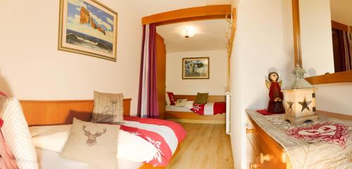 a bedroom with two beds and a mirror at Villa Artic Apartments in Campitello di Fassa
