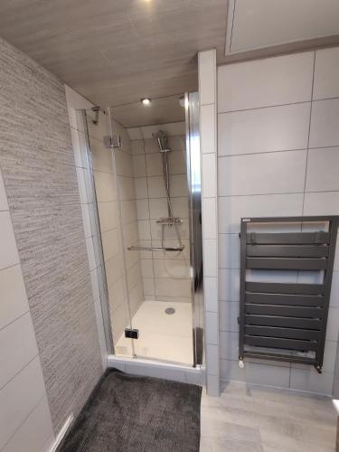 a shower with a glass door in a bathroom at La fa'Meuse escale in Vireux-Wallerand